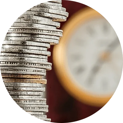 Stack of coins in front of a clock Stack of coins in front of a clock